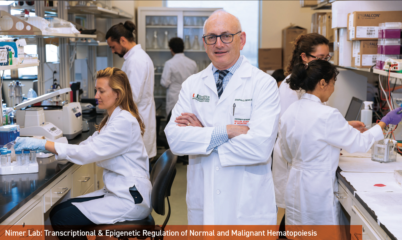 Dr. Stephen Nimer standing in his labs with other lab members in the background.