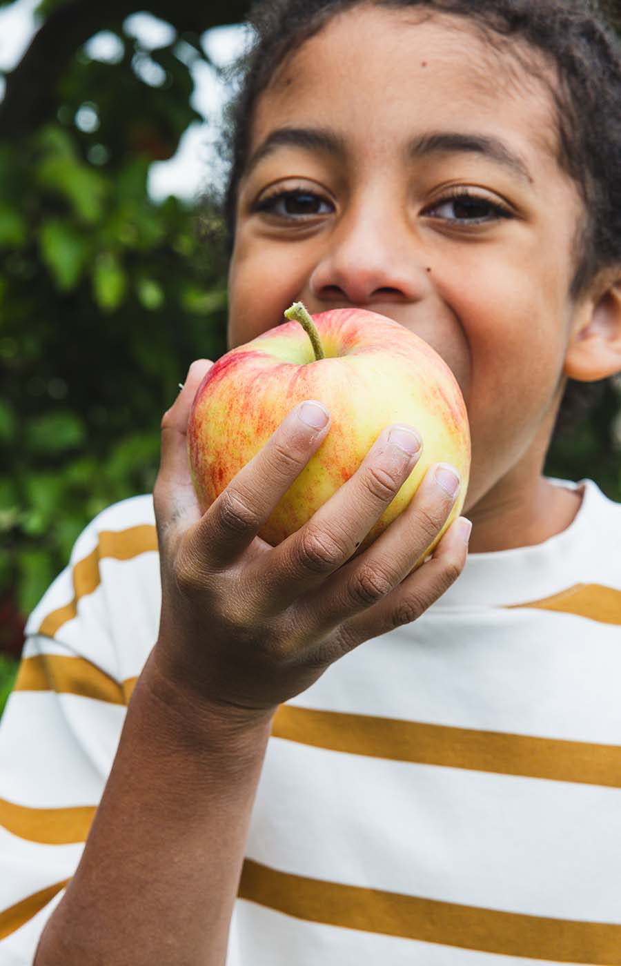 Child takes a bite out of an apple
