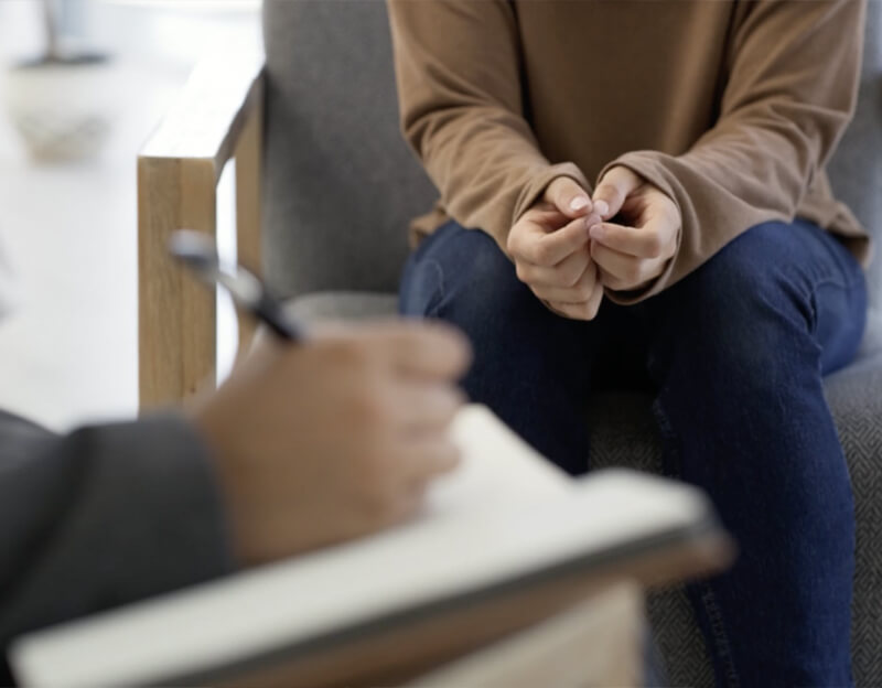 An unrecognizable woman having a therapy session with a psychologist. Closeup of a patient talking with a therapist during a psychology consultation