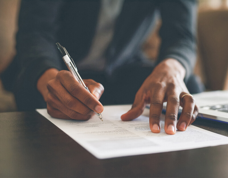 Cropped shot of an unrecognizable man filling out paperwork while doing his budget at home