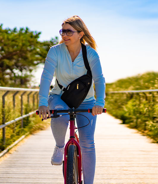 Mid adult woman riding bicycle at seaside