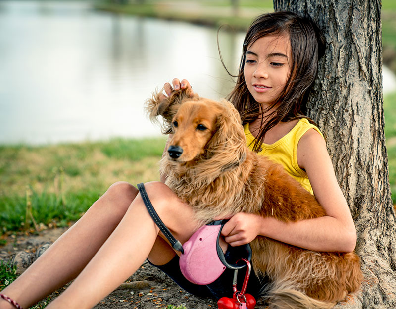Young girl holding her dog