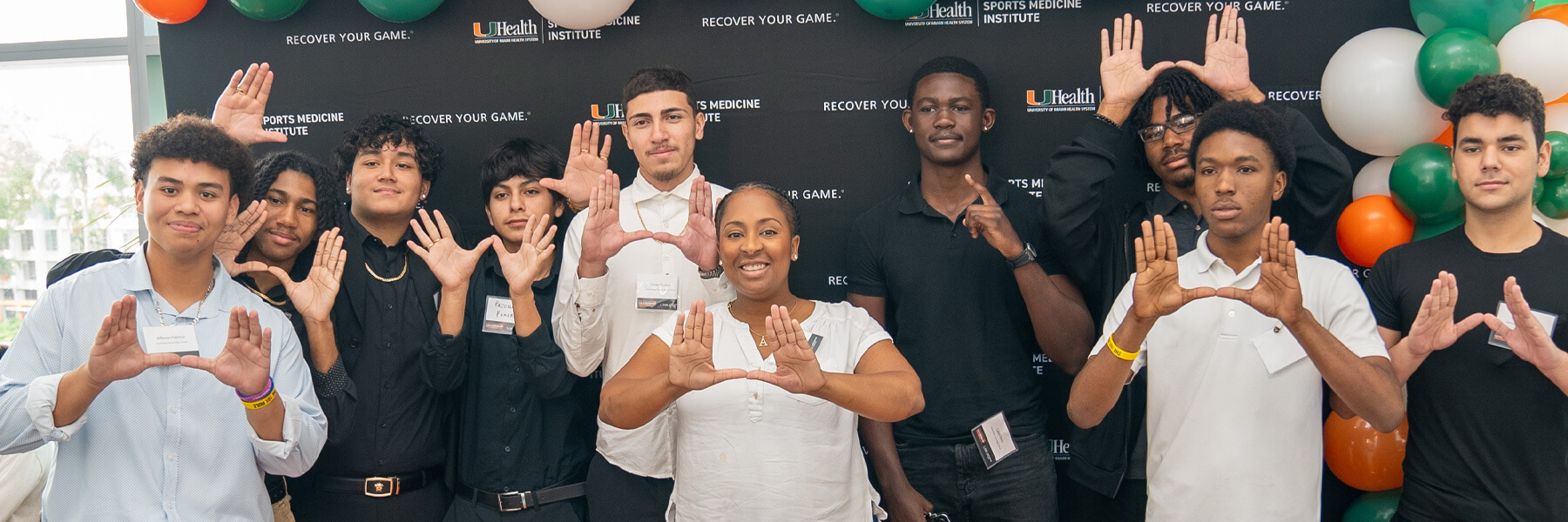 Several young people making a U sign with their hands