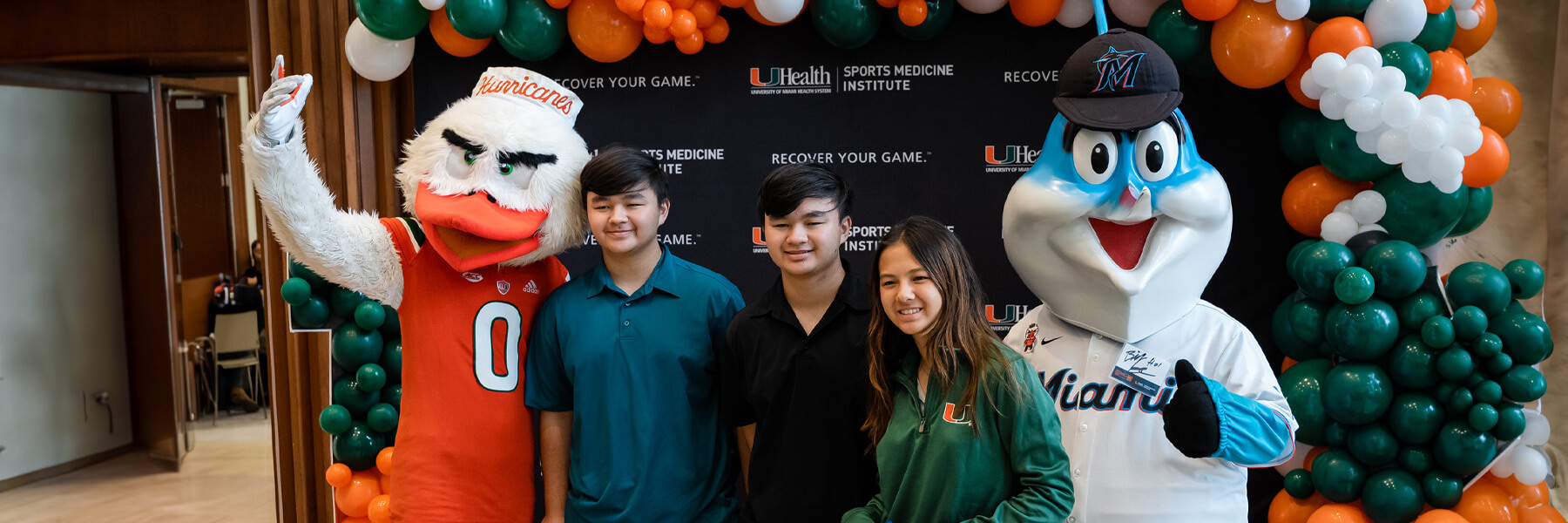 Several students standing next to Sebastian the Ivis on the left and Billy the Marlin on the right