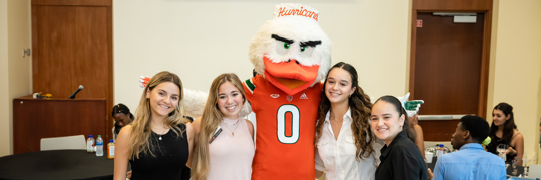 Several students standing next to Sebastian the Ivis