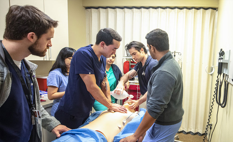 Medical students practicing on a manikin