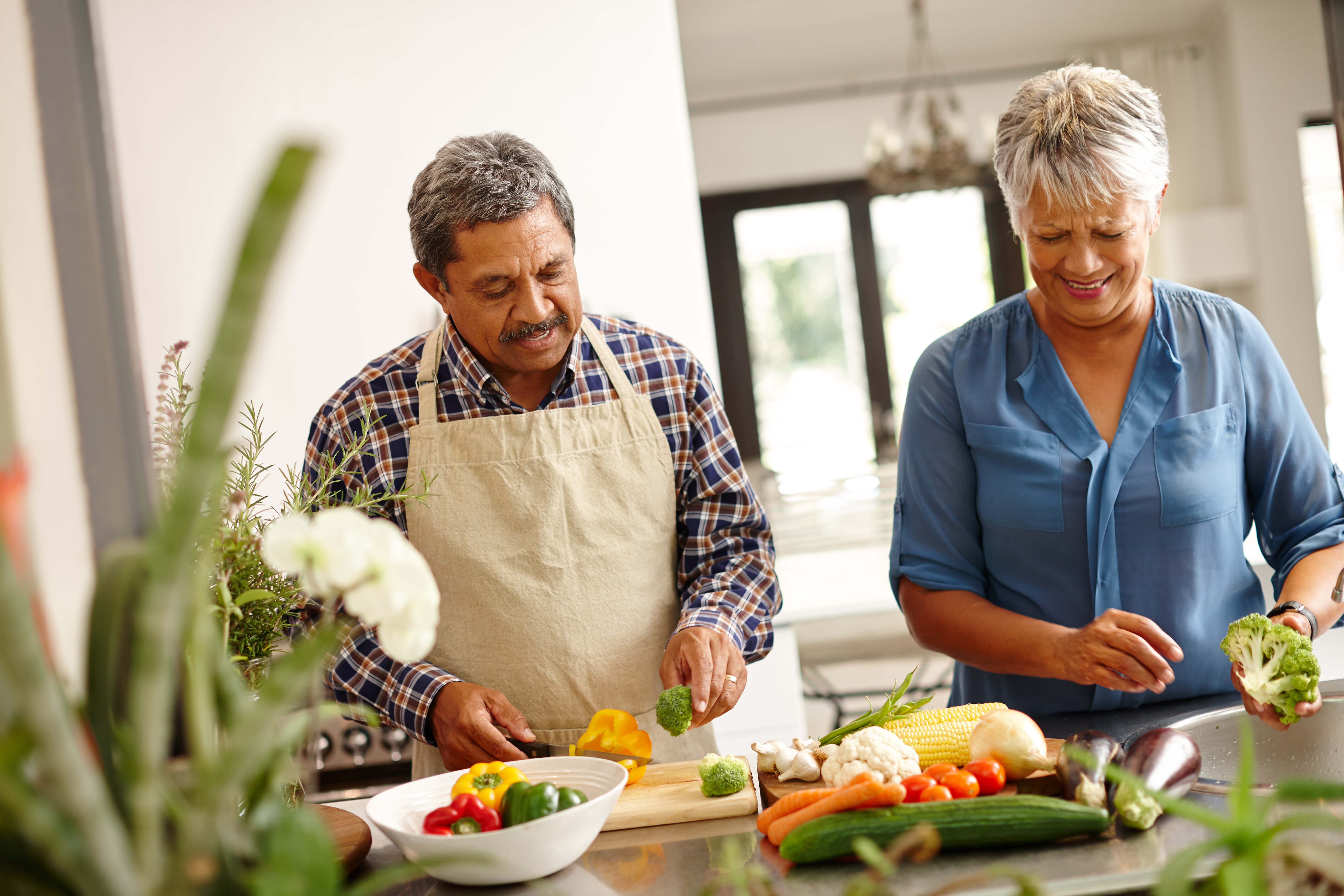 Couple cutting vegetables in a kitchen