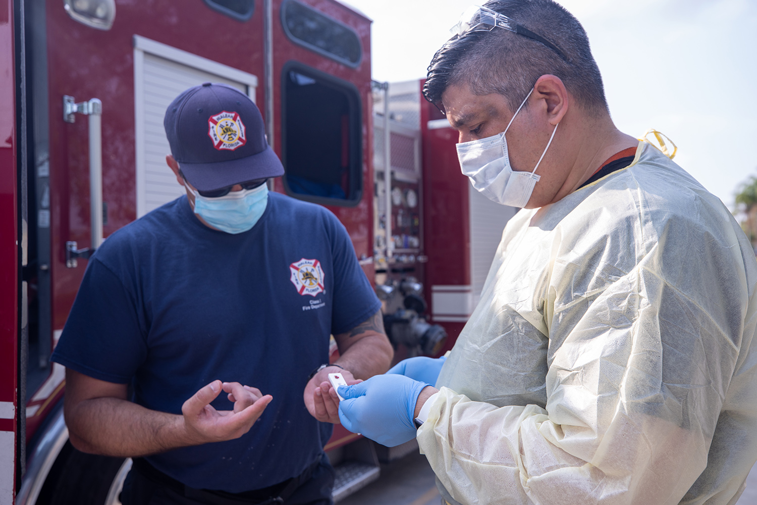 physician and firefighter look at a sample