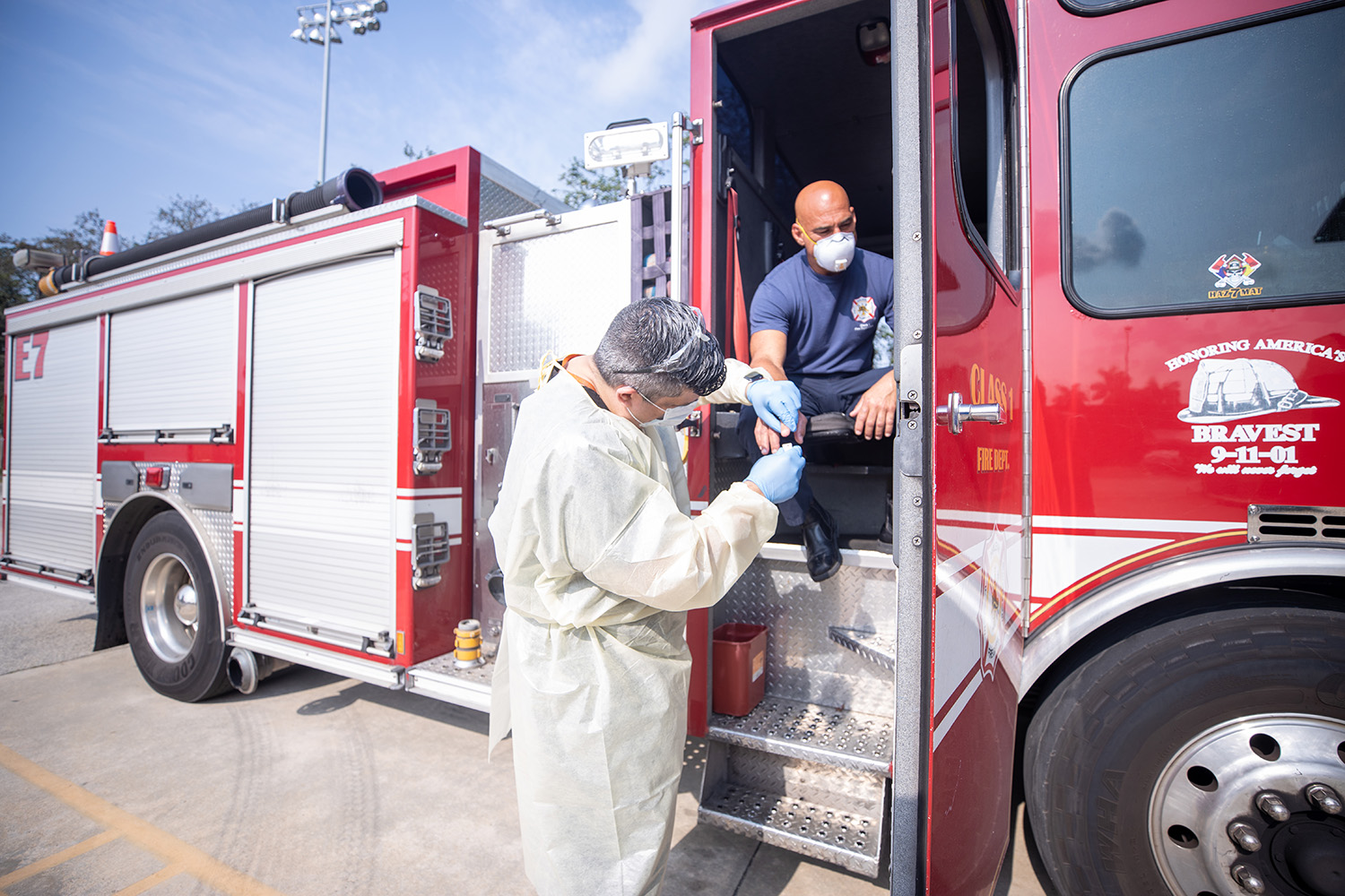 physician works with firefighter on the steps of a fire truck