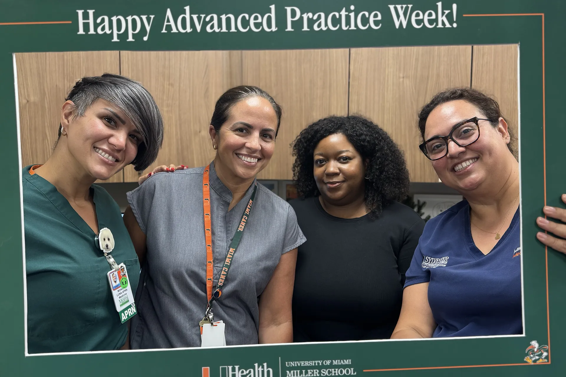 Nurses take a group photo with a fram around them that says Happy Advanced Practice Week
