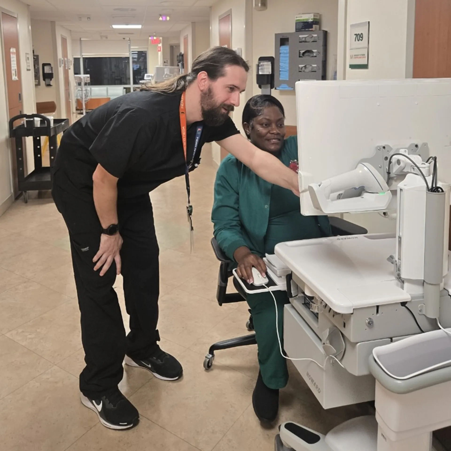Jared Chandler and nursing resident looking at a computer workstation
