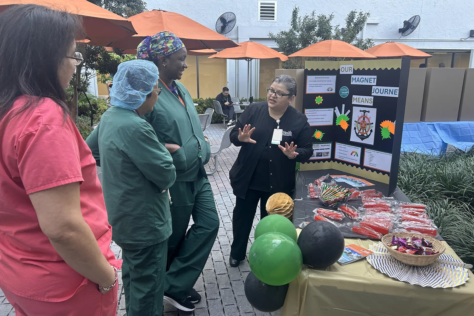 Nurses review patient safety awareness presentation in the courtyard
