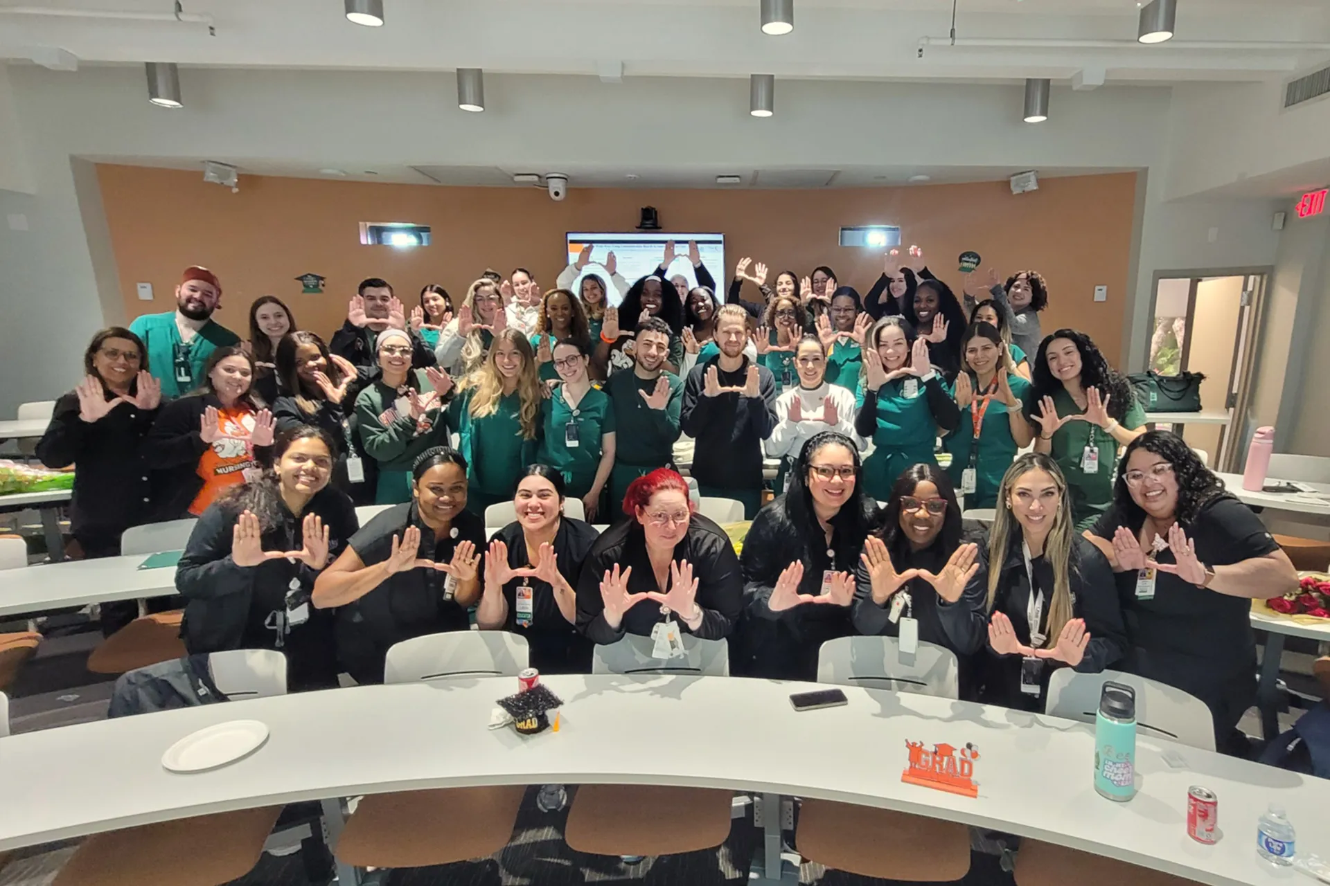 Group of nursing residents pose for a group photo in a classroom