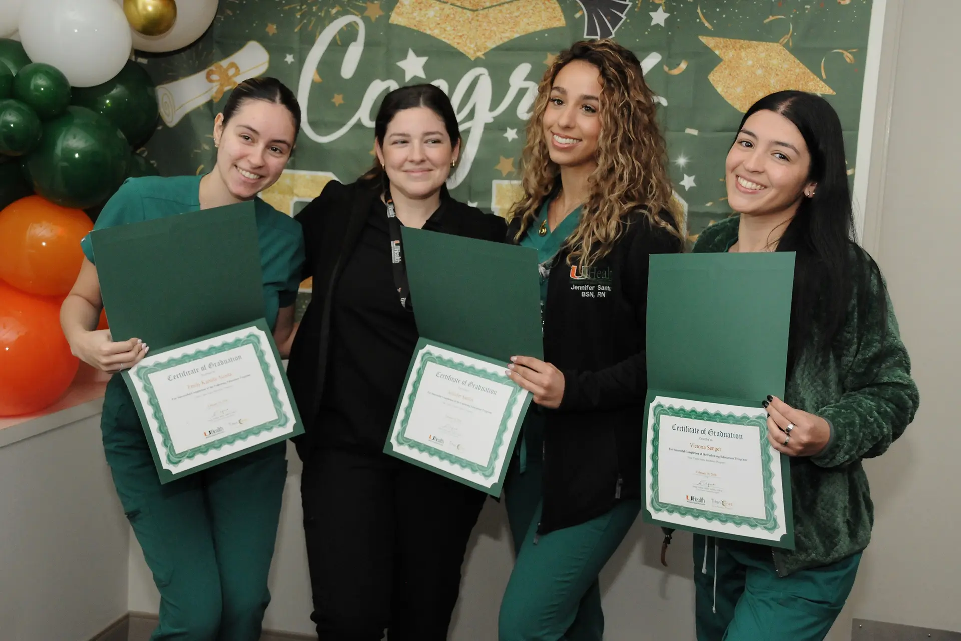 Nurses hold up their Certificates of Graduation