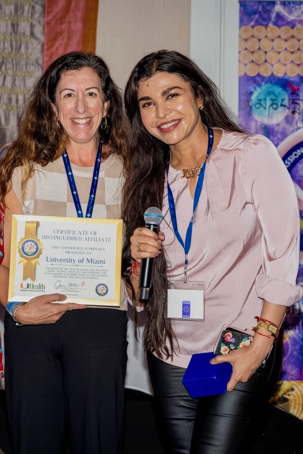 Two women pose with an award at an event