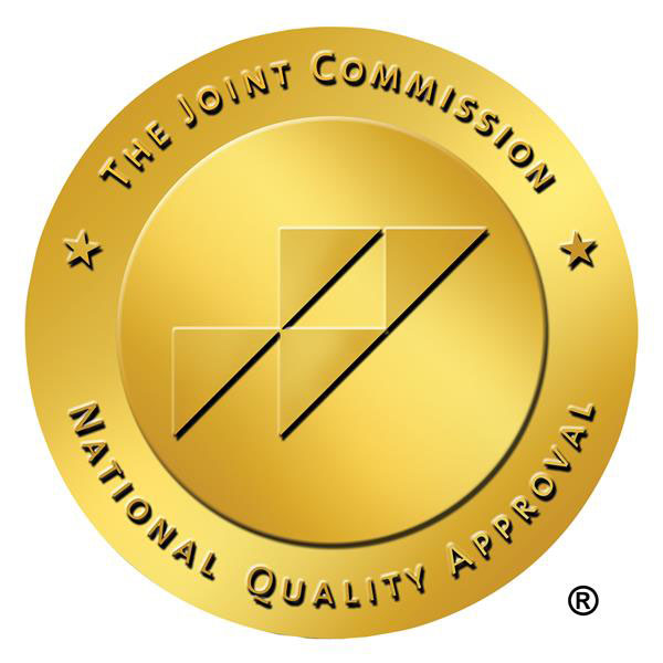 Gold circular seal reading The Joint Commission – National Quality Approval with a stylized geometric emblem at the center.